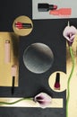 Top view of nail polishes, lipsticks, mascara, calla lily flowers on the golden, black surface Royalty Free Stock Photo