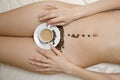 Top view of a naked woman lying on the bed with a fresh cup of coffee and beans on her thighs Royalty Free Stock Photo