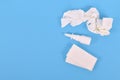 Top view of nasal spray bottle and used tissues used during common cold on blue background