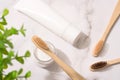 Top view on natural bamboo toothbrushes, mineral toothpowder and toothpaste tube on white table