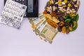 Top view of natural medicines, money, calculator, pills and different spices with green leaves on white background. Saving concept