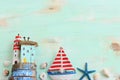 Top view of Nautical concept with sea life style objects as boat, driftwood beach houses, seashells and starfish over wooden Royalty Free Stock Photo