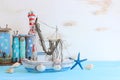 Top view of Nautical concept with sea life style objects as boat, driftwood beach houses, seashells and starfish over wooden Royalty Free Stock Photo