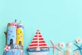 Top view of Nautical concept with sea life style objects as boat, driftwood beach houses, seashells and starfish over wooden Royalty Free Stock Photo