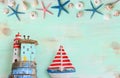 Top view of Nautical concept with sea life style objects as boat, driftwood beach houses, seashells and starfish over wooden Royalty Free Stock Photo