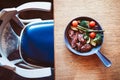 Top view of navarin dish on a wooden table next to a vintage looking chair