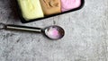 Top view of neapolitan ice cream and a spoon on a textured background with space for text Royalty Free Stock Photo