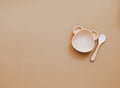 Top view neutral baby tableware on brown background, Royalty Free Stock Photo