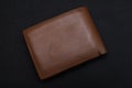 New brown genuine leather wallet isolated on black background