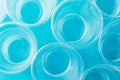 Top view of new clean empty transparent disposable plastic glasses on bright blue background Royalty Free Stock Photo