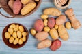 top view of new potatoes in bowl and others of different types in basket with garlic crusher salt and other potatoes on wooden