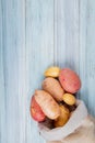 top view of new russet and red potatoes spilling out of sack on wooden background with copy space Royalty Free Stock Photo