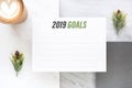 Top view of new year 2019 goals on white paper card and coffee c