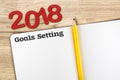 Top view of 2018 new year red number and goals setting with blank open notebook and yellow pencil on wooden table top,Mock up for Royalty Free Stock Photo