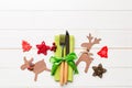 Top view of new year utensils on napkin with holiday decorations and reindeer on wooden background. Christmas dinner concept with