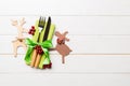 Top view of new year utensils on napkin with holiday decorations and reindeer on wooden background. Christmas dinner concept with Royalty Free Stock Photo