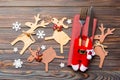 Top view of new year utensils on napkin with holiday decorations and reindeer on wooden background. Close up of christmas dinner Royalty Free Stock Photo