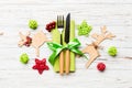 Top view of new year utensils on napkin with holiday decorations and reindeer on wooden background. Close up of christmas dinner Royalty Free Stock Photo