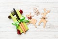 Top view of new year utensils on napkin with holiday decorations and reindeer on wooden background. Close up of christmas dinner Royalty Free Stock Photo