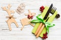 Top view of new year utensils on napkin with holiday decorations and reindeer on wooden background. Close up of christmas dinner Royalty Free Stock Photo