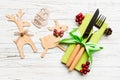 Top view of new year utensils on napkin with holiday decorations and reindeer on wooden background. Close up of Royalty Free Stock Photo