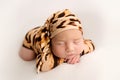 Top view of a newborn baby girl sleeping in a tiger jumpsuit and a brindle cap Royalty Free Stock Photo