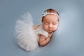 Top view of a newborn baby girl sleeping in a white ballerina tutu dress