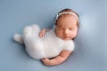 Top view of a newborn baby girl sleeping in a white bodysuit with a blue bandage