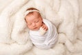 Top view of a newborn baby girl sleeping in a white cocoon with a white bandage Royalty Free Stock Photo