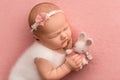 Newborn baby girl sleeping in a white overalls, with a white bandage on her head Royalty Free Stock Photo