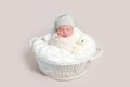 Newborn baby in white wrap laying on basket Royalty Free Stock Photo