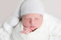 Newborn baby in white wrap laying on basket Royalty Free Stock Photo