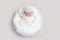 Newborn baby in white wrap laying on basket Royalty Free Stock Photo