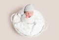 Newborn baby in white wrap laying on basket Royalty Free Stock Photo