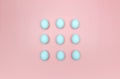 Top view of nine blue eggs on pink background. Creative easter composition, flat lay, copy space. Royalty Free Stock Photo