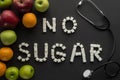 Top view of no sugar phrase made of sugar cubes with stethoscope and fruits