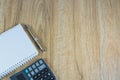 Top view of note book, pen and calculator on wooden table Royalty Free Stock Photo