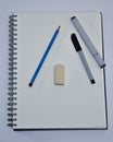 Top view of a notebook with eraser, pen, pencil and marker Royalty Free Stock Photo