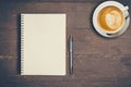 Top view notebook and pen with coffee cup on wood table