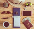 Top view of notebook, pen, sunglasses, coffee cup, passport, mon