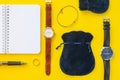 Top view of notebook, pen, wristwatch, gold ring, bracelet, jewelry pouches. Concept of elegance, wealth, men`s accessories,