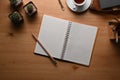 Top view notebook, pencil, coffee cup and cactus on wooden desk. Royalty Free Stock Photo