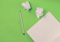 Top view of notebook with pencil and white crumpled paper ball on green background. Concept of no idea, education, minimalism. Royalty Free Stock Photo