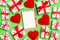 Top view of notebook, white gift boxes and red textile hearts on colorful background. Valentine`s Day concept Royalty Free Stock Photo