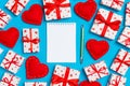 Top view of notebook, white gift boxes and red textile hearts on colorful background. Valentine`s Day concept Royalty Free Stock Photo