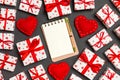 Top view of notebook, white gift boxes and red textile hearts on colorful background. Valentine`s Day concept Royalty Free Stock Photo