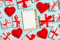 Top view of notebook, white gift boxes and red textile hearts on colorful background. Valentine`s Day concept Royalty Free Stock Photo