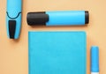 Top view of notepad and blue markers on an orange desk Royalty Free Stock Photo