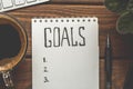 Top view of notepad with Goals List, cup of coffee on wooden table, goals concept Royalty Free Stock Photo