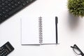 Top view of notepad , keyboard and a pen on white background